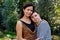 Portrait of down syndrome adult man with mother standing outdoors in garden.