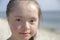 Portrait of down syndrome girl smiling on background of the seaÑŽ