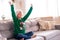 Portrait dreaming boy with closed eyes in Santa hat and Christmas costume sitting at home hands up. New Year Holidays