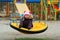 Portrait of dreaming three year old toddler girl with colorful braided hair, swinging outdoor