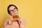 Portrait of dreaming young girl tasting Italian pizza isolated on yellow studio background. World pizza day