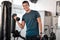 Portrait, dumbbells and man in gym smile with earphones for streaming music while exercising. Sports workout, fitness