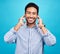 Portrait, earphones and happy man with music in studio, relax and smile on blue background. Radio, face and asian male