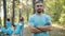 Portrait of eco-friendly man volunteer standing in forest with arms crossed