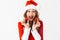 Portrait of ecstatic woman 20s wearing Santa Claus red costume smiling and holding Christmas decorations, isolated over white