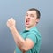 Portrait of ecstatic young man celebrating victory or win against gray background