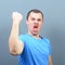 Portrait of ecstatic young man celebrating victory or win against gray background