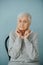 Portrait of elderely grey haired woman in a comfortable sweater at home