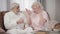 Portrait of elderly Caucasian couple arguing at home. Beautiful mature woman talking emotionally, elegant senior man