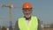 Portrait of an elderly engineer in protective clothing at a construction site.