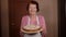 Portrait of an elderly grandmother in an apron with an apple pie in her hands.