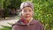 Portrait of an elderly grandmother with gray hair in a hat in the park in autumn