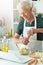 Portrait of elderly making salad at kitchen