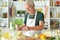 Portrait of elderly making salad at kitchen