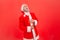 Portrait of elderly man with gray beard wearing santa claus costume holding hands on belly and can`t stop laughing hard, hearing