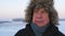 Portrait Elderly Man With Wrinkles In Jacket And Fur Hat Outdoor In Winter