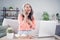 Portrait of elderly retired pensioner cheery woman using laptop sitting on divan communicating laughing at home house