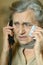 Portrait of an elderly sick woman calls the doctor.