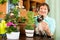 Portrait of elderly woman with decorative plants and cat