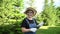 Portrait of an elderly woman in a hat and overalls is holding a garden tool. Video 360 degrees.