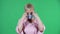 Portrait elderly woman looking at the camera and puts on medical mask. Gray haired grandmother with short hair in a pink