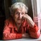 Portrait of an elderly woman pensioner sitting at kitchen