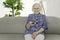 portrait of elderly woman sit on the sofa at home wath television