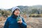 Portrait of an elderly woman, wearing warm clothes, drinking yerba mate at the countryside in the midday