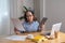 Portrait of an elderly woman working inside the house using laptops and tablets to work and check important documents for