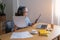 Portrait of an elderly woman working inside the house using laptops and tablets to work and check important documents for