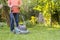 Portrait of eldery senior man working in the summer garden walking on a grass field