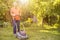 Portrait of eldery senior man working in the summer garden walking on a grass field