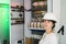 Portrait of an electrician woman in a white helmet next to high-voltage electrical equipment.A girl in an engineering helmet is on