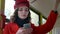 Portrait of an elegant young girl in a red coat. Uses a smartphone in public transport. Prints a text message on the bus