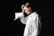 Portrait of an elegant young woman in a white shirt and black pants. Interesting studio light