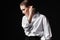 Portrait of an elegant young woman in a white shirt and black pants. Interesting studio light