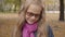 Portrait of an embarrassed Caucasian teenage girl looking at the camera and smiling. Young schoolgirl in photochromic