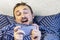 Portrait of emotional cheerful man with unshaven face playing mobile game on smartphone in bed