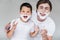 portrait of emotional father and son with shaving foam on faces
