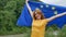 Portrait of emotional girl with the flag of the European Union which is going to study in EU smiling and looking at the