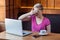 Portrait of emotional scared happy young businesswoman in pink t-shirt is sitting in cafe and covering the eyes to herself with