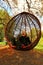 Portrait of emotional stylish three year old girl in a red weaved swing in the autumn park