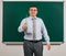 Portrait of a emotional talking man dressed as a school teacher in business suit, posing at blackboard background - learning and