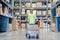 Portrait of employee female warehouse professional worker in uniform working in inventory with stacked up shelves in logistics