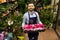 portrait of an employee of a flower shop with perfect small red flowers in his hands