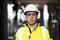 Portrait of employee serious asian man engineer worker wearing safety uniform, goggles and hardhat looking at camera on