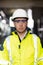 Portrait of employee serious asian man engineer worker wearing safety uniform, goggles and hardhat looking at camera on