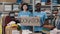 Portrait of energetic colleagues looking at the camera and smiling while holding banner with donation word in charity