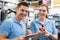 Portrait Of Engineer And Apprentice Examining Component In Factory