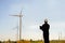 Portrait of engineer asian man holding laptop with the wind turbine in background